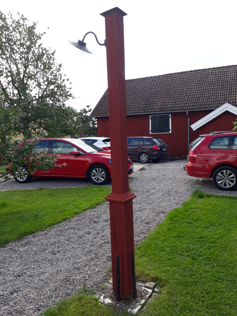 Lyktstolpe målad i falu rödfärg hos Lillemor Lindberg.